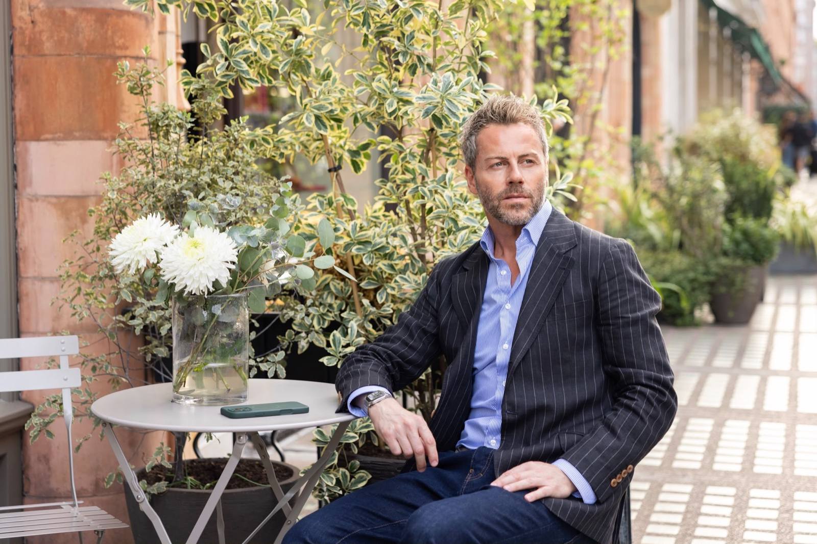 Gilberto Ramerini in a pinstripe blazer at an outdoor café